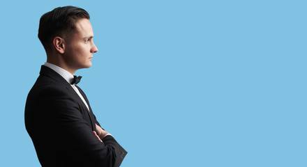 profile of a young handsome brunete man in black suit