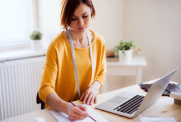 Young creative woman in a studio, startup of small tailoring business.