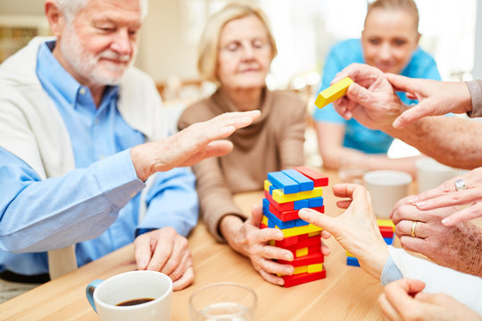 Senioren mit Demenz bauen Turm aus Bausteinen