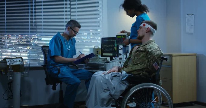 Soldier sitting in wheelchair among doctors