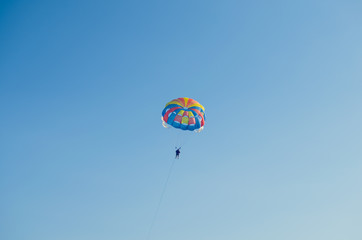 Parasailing is an extreme sport, people fly by parachute against the blue sky