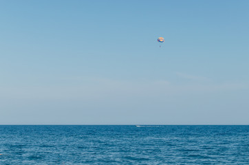 Parasailing is an extreme sport, people fly by parachute against the blue sky