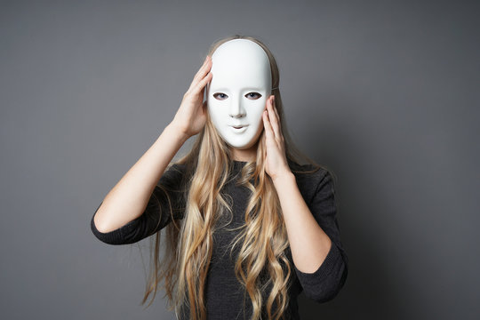 mysterious young woman adjusting her mask with her hands