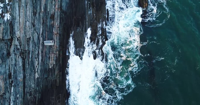 A man watching the waves hit the rocks down below in Curtis island lighthouse Camden Maine USA