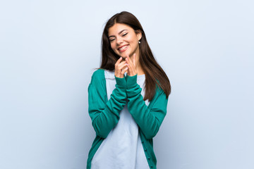 Teenager girl over blue wall scheming something