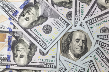 old 100 dollar bill surrouded by new 100 dollar bills