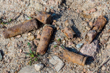 Old rusty submachine gun shells in the sand on the territory of the former shooting range in Kronstadt.