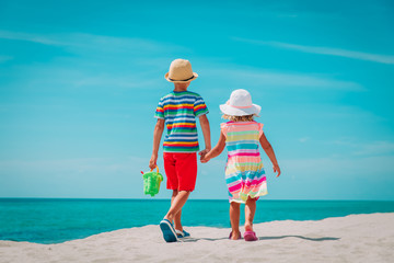 little boy and girl walking on beach