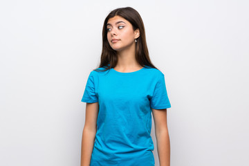 Fototapeta premium Teenager girl with blue shirt making doubts gesture looking side