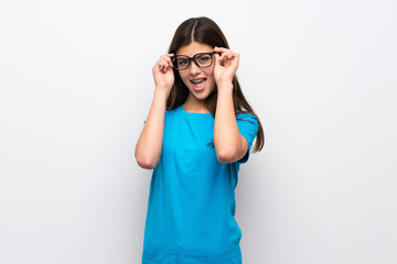 Teenager girl with blue shirt with glasses and surprised