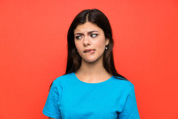Teenager girl with blue shirt having doubts and with confuse face expression