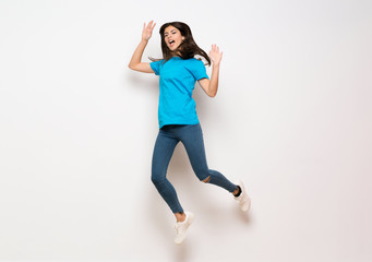 Fototapeta premium Teenager girl jumping over isolated white wall