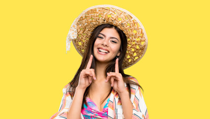 Teenager girl on summer vacation smiling with a happy and pleasant expression over isolated yellow background