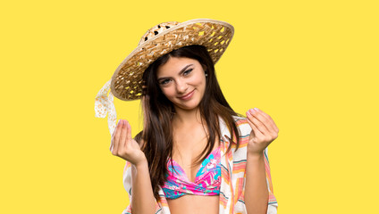 Teenager girl on summer vacation making money gesture over isolated yellow background