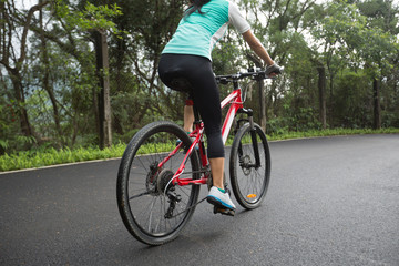 Obraz premium Woman cyclist riding Mountain Bike on forest trail