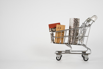 Wood house model in shopping cart on white background. Real Estate market, Trading Estate, Mortgage Concepts.