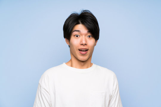 Asian Man On Isolated Blue Background With Surprise Facial Expression