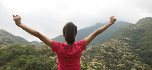 young woman  feel strong at forest mountain top