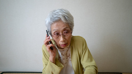 電話で不安そうに話すおばあちゃん