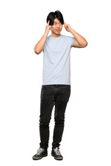 A full-length shot of a Asian man with blue shirt having doubts and thinking over isolated white background