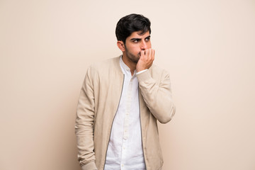 Young man over isolated wall having doubts