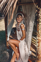 beautiful young cheerful woman in turban having fun outdoors at natural tropical background