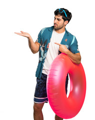 Man in trunks holding copyspace imaginary on the palm to insert an ad over isolated white background