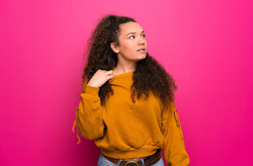 Teenager girl over pink wall with tired and sick expression