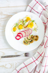 Healthy breakfast with quail eggs, radish, mushrooms and microgreens. Diet on a plate