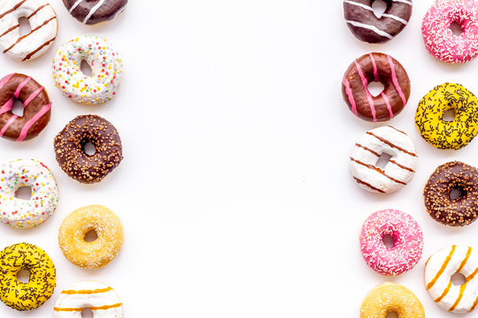 Glazed decorated donuts for sweet break on white background flat lay copy space