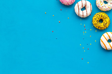 Traditional american donuts of different flavors on blue background flat lay mockup