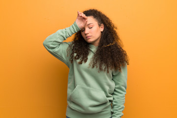 Teenager girl over ocher wall with tired and sick expression
