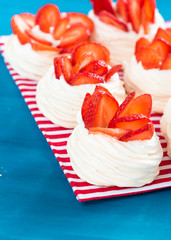 Beautiful pavlova cakes with strawberries on a blue background. Selective focus. Tasty sweet breackfast. Wedding morning. Meringue with cream.