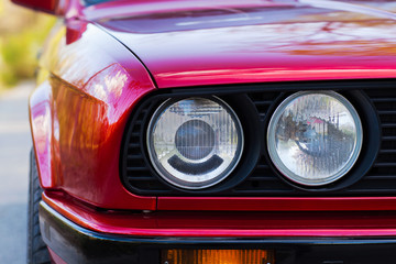 Obraz na płótnie Canvas Headlights of a red, old, retro car, closeup
