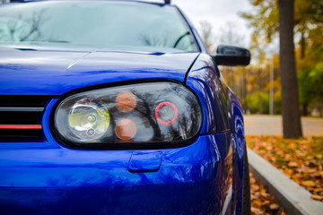 Modified xenon headlights of blue modern car. Parked on the street