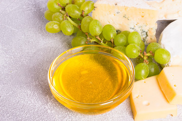 Snacks with wine - various types of cheeses, figs, nuts, honey, grapes