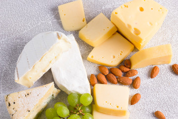 Snacks with wine - various types of cheeses, figs, nuts, honey, grapes