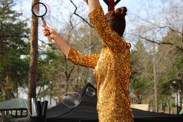 girl in beautiful shiny dress with soap bubbles