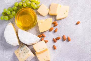 Snacks with wine - various types of cheeses, figs, nuts, honey, grapes