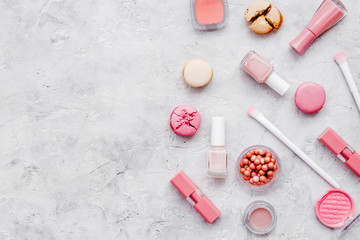 make-up accessories, fashion stylish cosmetics and macaroon on stone desk background top view copy space