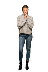 A full-length shot of a Blonde woman with turtleneck scheming something over isolated white...