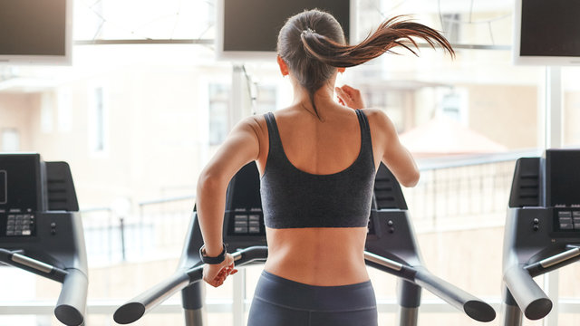 Sportswoman running on treadmill in gym