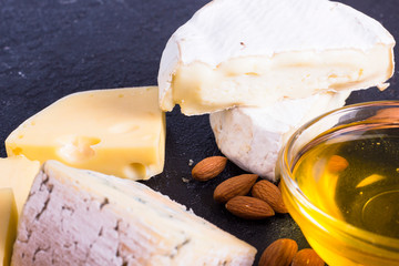 Snacks with wine - various types of cheeses, figs, nuts, honey, grapes