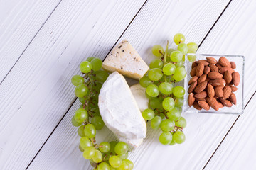 Snacks with wine - various types of cheeses, figs, nuts, honey, grapes