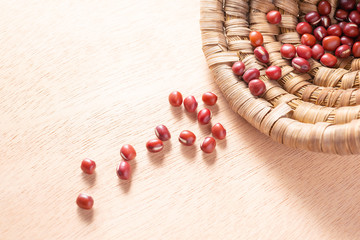 Red dried beans spilling out of bamboo basket