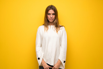 Blonde woman over yellow wall portrait