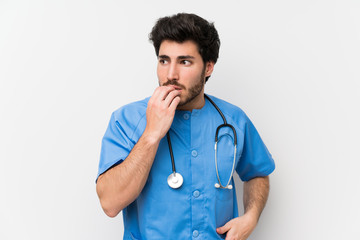 Surgeon doctor man over isolated white wall nervous and scared