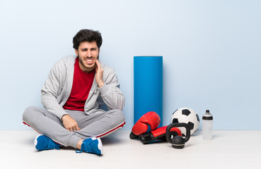 Sport man sitting on the floor with toothache
