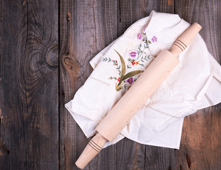 new wooden rolling pin on a textile napkin with embroidery