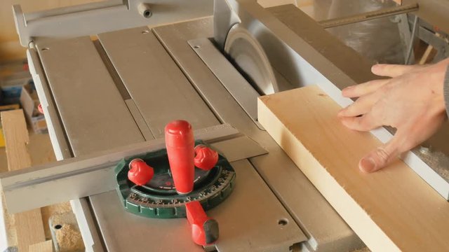 Circular in action. Woodworker rip cut saws ash plank on a table saw. Joiner at work.